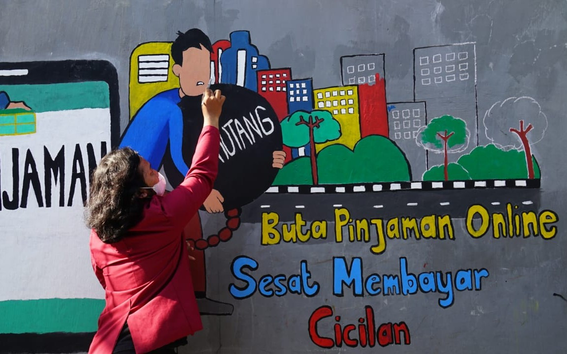 Mahasiswa UM Surabaya melukis mural ingatkan bahaya pinjol illegal. Foto: Humas UM Surabaya
