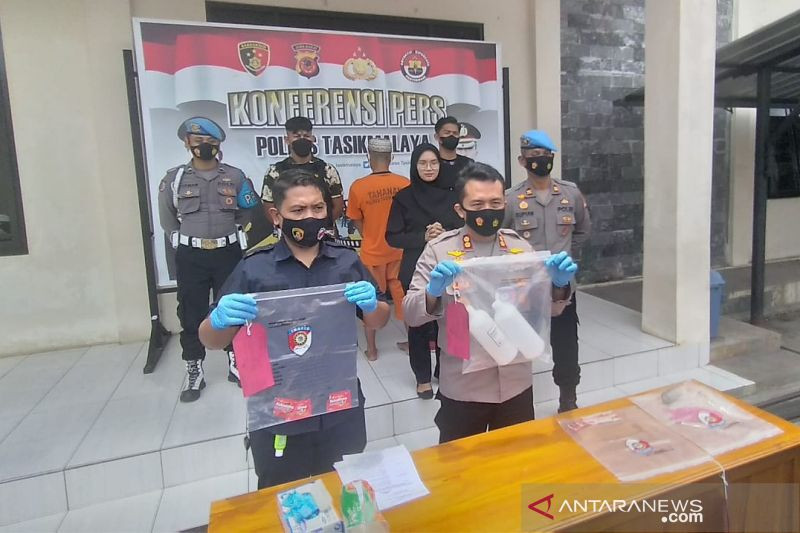 Polisi menunjukkan barang bukti dan tersangka dalam kasus minuman keras oplosan yang menyebabkan lima orang tewas di Markas Polres Tasikmalaya, Jawa Barat, Rabu (13/10/2021). ANTARA/HO-Polres Tasikmalaya.
