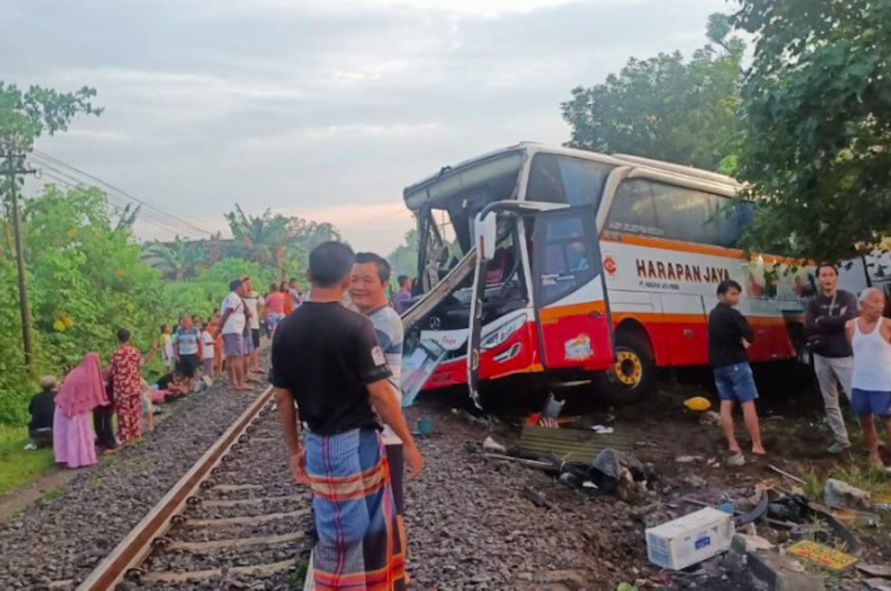 Warga melihat kondisi bus yang ringsek usai tertabrak kereta api Rapih Dhoho di Ketanon, Tulungagung, Jawa Timur, Minggu (27/2/2022) pagi. Foto: ANTARA/HO-warganet