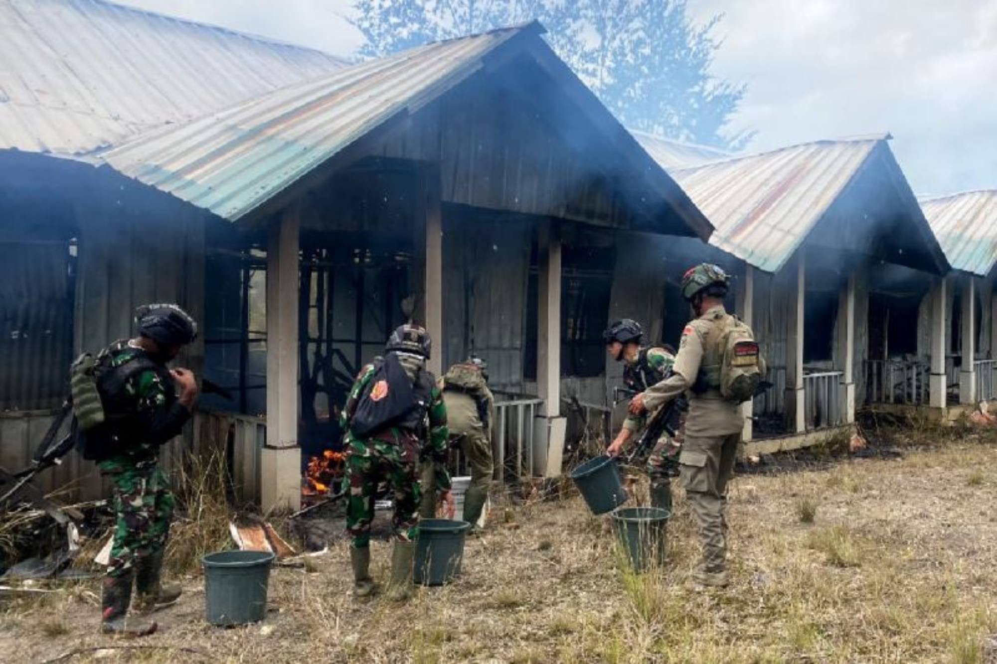 Personel TNI-Polri berupaya memadamkan perumahan petugas kesehatan yang dibakar KKB di Ilaga, Kabupaten Puncak, Papua Tengah, Senin (11/9) Foto: ANTARA/HO/Dok Satgas Yonif Raider 300/Bjw