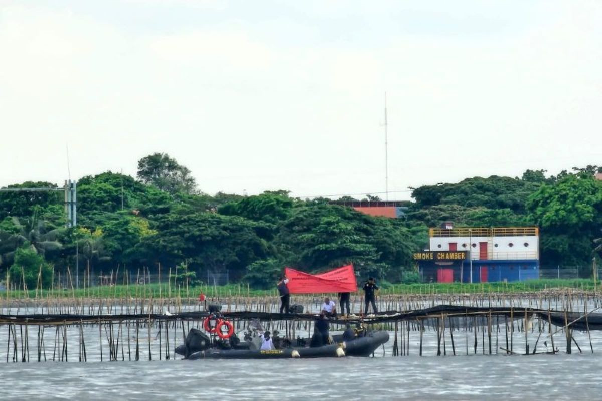 Petugas dari KKP RI melakukan pemasangan spanduk penyegelan terhadap pemasangan pagar laut dari bambu di perairan pantai utara Kabupaten Tangerang, Banten. (ANTARA/Azmi Samsul Maarif)