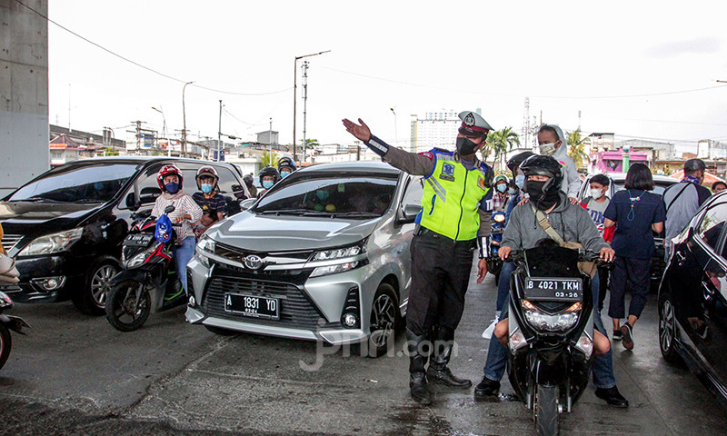Petugas kepolisian memberhentikan kendaraan di pintu masuk Ancol Taman Impian, Jakarta, Sabtu (15/5). Pengelola Ancol Taman Impian menutup seluruh area rekreasi dan wisata selama satu hari pada Sabtu (15/5) untuk dilakukan penyemprotan disinfektan dan evaluasi penguatan protokol kesehatan.